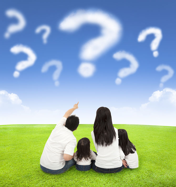 31497564 - happy family sitting on a meadow with query of clouds in the blue sky background